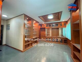 Spacious living room with built-in wooden cabinets and shelves