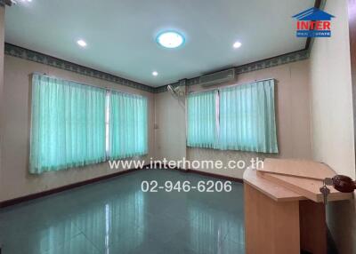 Living room with tiled flooring and large windows with curtains