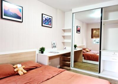 A cozy bedroom with a desk and mirror closet