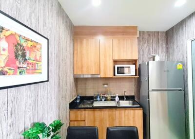 Modern kitchen with wooden cabinets, stainless steel appliances, and decorative artwork