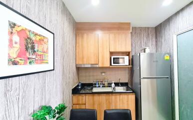 Modern kitchen with wooden cabinets, stainless steel appliances, and decorative artwork