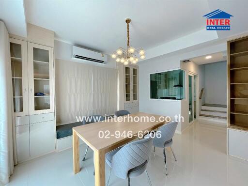 Modern dining room with light wood furniture and a contemporary chandelier