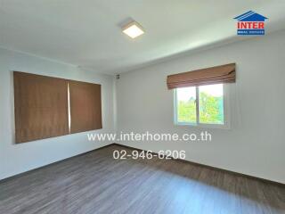 Bedroom with wooden flooring and large windows