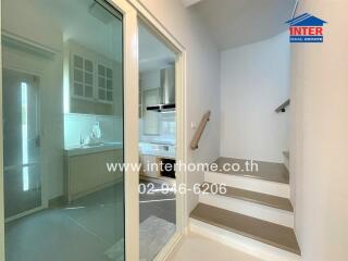 View of a kitchen through a glass door next to a staircase