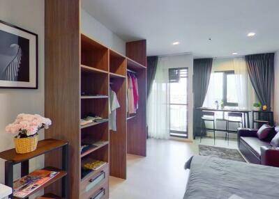 Modern studio apartment with living area, wardrobe, and dining space