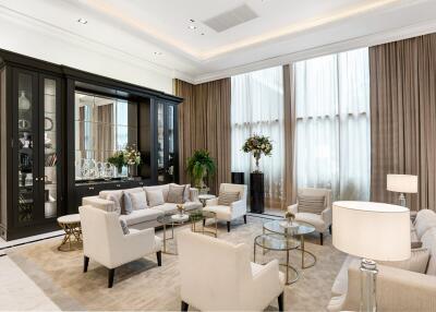 Spacious and elegantly furnished living room with high ceilings, large windows, and comfortable seating.