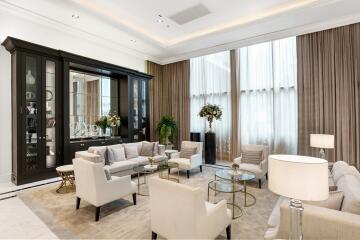 Spacious and elegantly furnished living room with high ceilings, large windows, and comfortable seating.