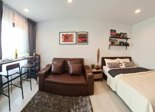 Modern studio apartment with living area and bed