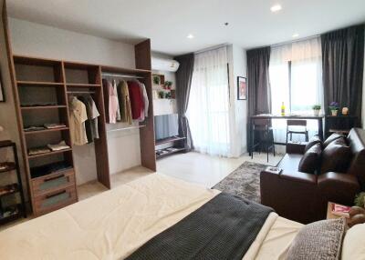 spacious bedroom with open closet and seating area