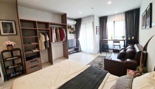 spacious bedroom with open closet and seating area