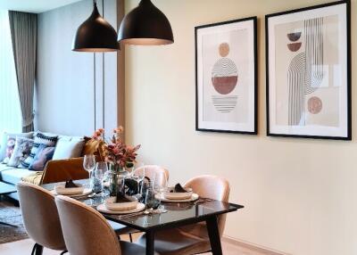 Modern dining area with a table set for four, contemporary decor, and a view into a cozy living space