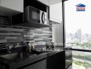 modern kitchen with black and white cabinetry and city view
