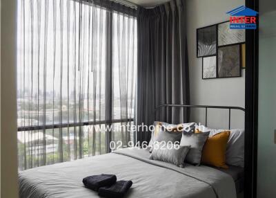 Bedroom with large windows and city view