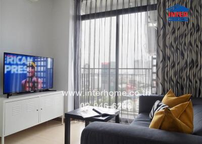 Modern living room with a large window, TV, and a sofa