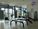 Modern fitness center with equipment and large windows