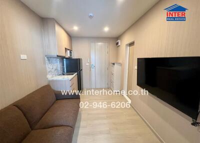 Modern small living area with kitchenette and wall-mounted TV