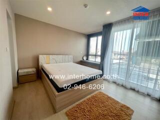 Modern bedroom with double bed, bedside table, window with curtains, and rug