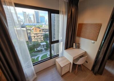 Bedroom with a city view, desk, and chair.