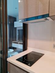 Modern kitchen area with electric cooktop and view of living room