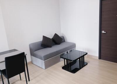 Minimalist living room with grey sofa and black coffee table