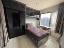 Modern bedroom with single bed, built-in wardrobe, and city view