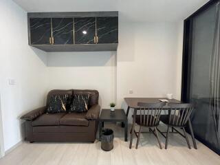 Modern living area with a brown sofa and a dining table