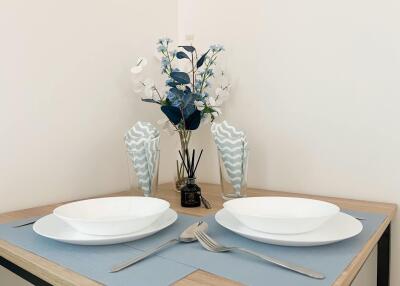 Elegant dining area setup with tableware and floral arrangement