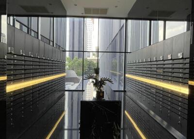 Mailroom with reflective black floors, centered flower arrangement, and wall of mailbox slots