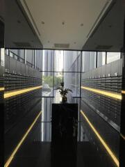 Mailroom with reflective black floors, centered flower arrangement, and wall of mailbox slots