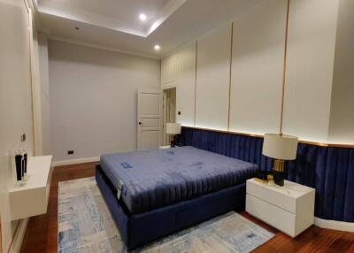 Modern bedroom with contemporary design, featuring a large bed with a plush headboard, wooden flooring, and ambient lighting.