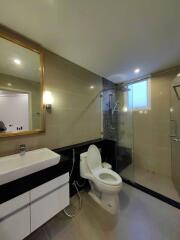 Modern bathroom with glass shower, toilet, and sink