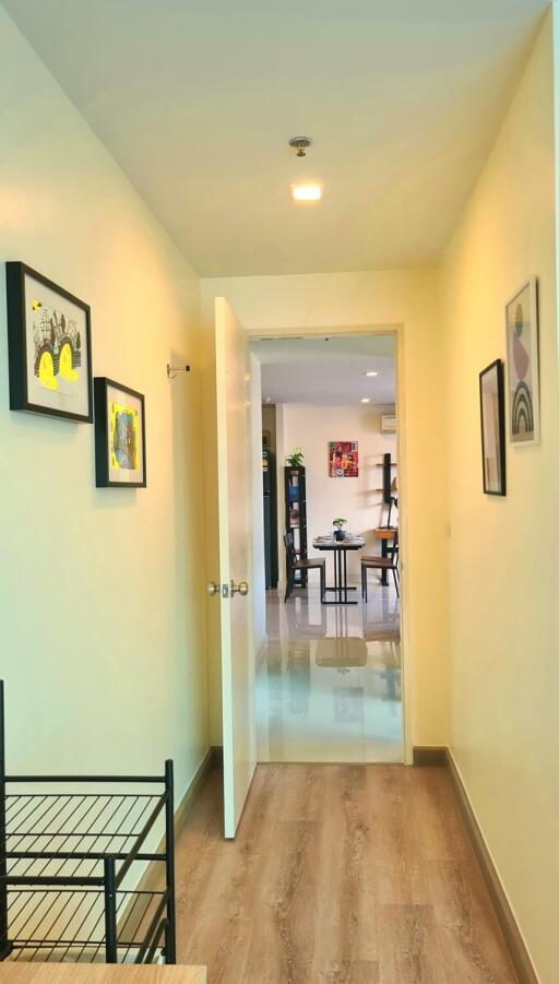 Hallway leading to the living space with artwork on walls