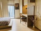 Modern bedroom with wooden flooring, a bed, a work desk, and large windows with blinds