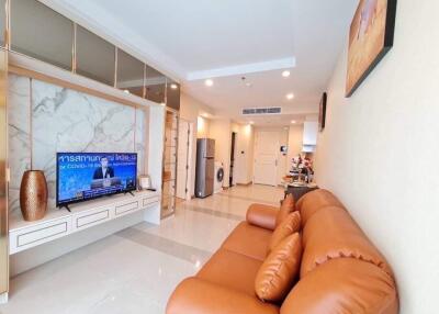 Modern living room with a brown leather sofa and wall-mounted TV