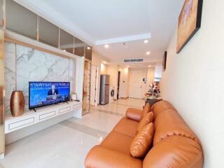 Modern living room with a brown leather sofa and wall-mounted TV