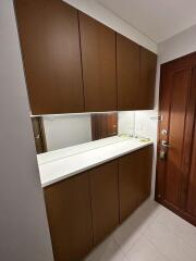 Entryway with wooden cabinets and a large mirror