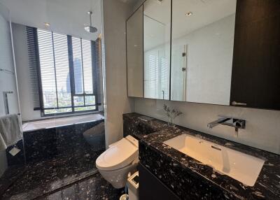 Modern bathroom with black marble accents and large windows
