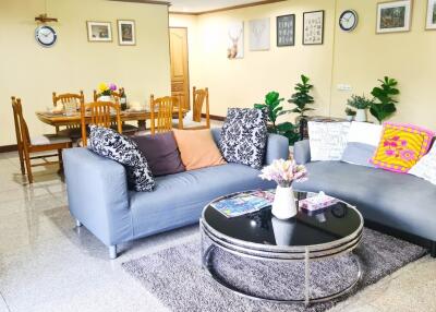 Well-furnished living room with sofa, dining area, and wall decorations