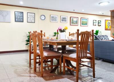 Spacious dining area with wooden table and chairs, adjacent to a cozy living room