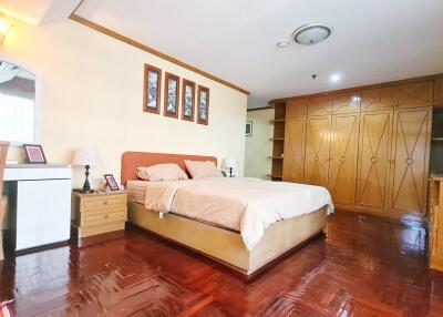 Spacious bedroom with wooden flooring and ample storage