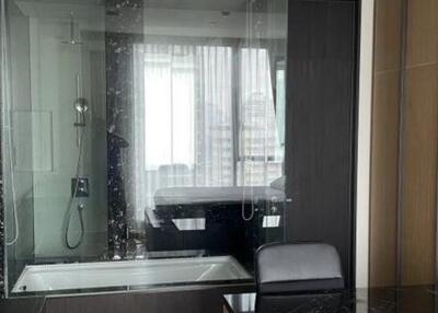 Modern bathroom with glass shower enclosure and chair