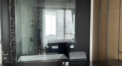 Modern bathroom with glass shower enclosure and chair