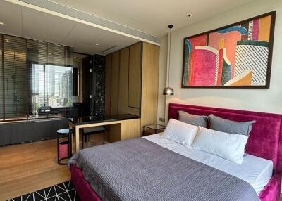 Modern bedroom with a city view, plush bed with grey bedding, and artistic décor