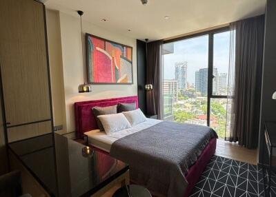 Modern bedroom with a large window overlooking the city