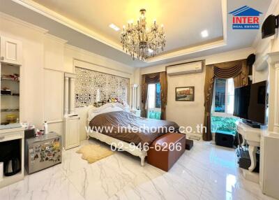 Luxurious bedroom with chandelier, double bed, large windows, and elegant decor