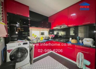 Modern kitchen with red cabinetry and washing machine