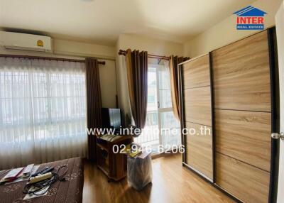 Bedroom with large window and wooden wardrobe