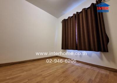 Empty bedroom with wooden floor and dark curtains