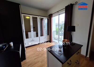 Bedroom with wardrobe, balcony access, and wooden flooring