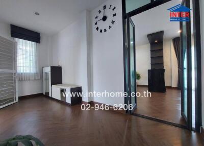 Modern living room with dark wood flooring and clock on the wall